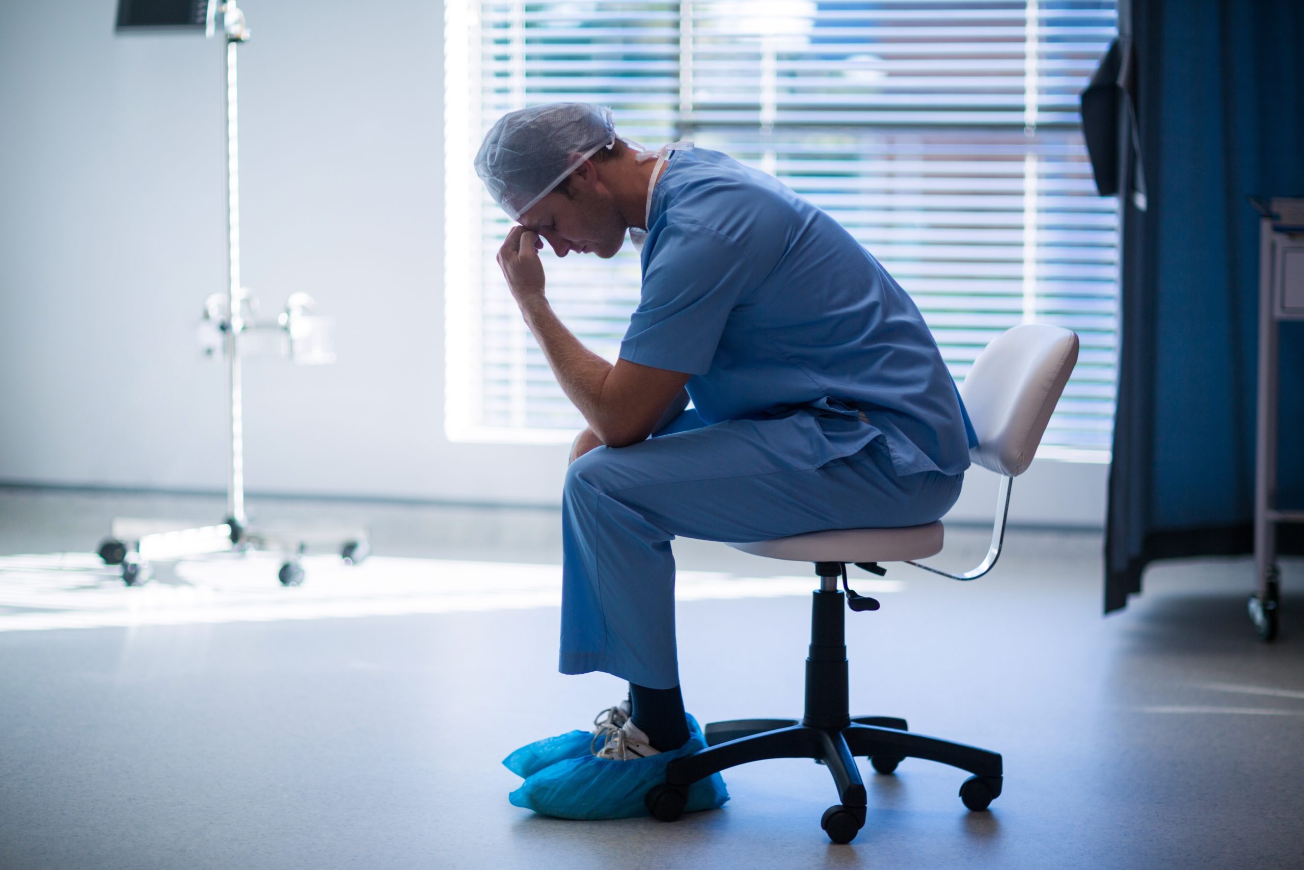 Male Nurse sits in the hospital and reflects on critical care