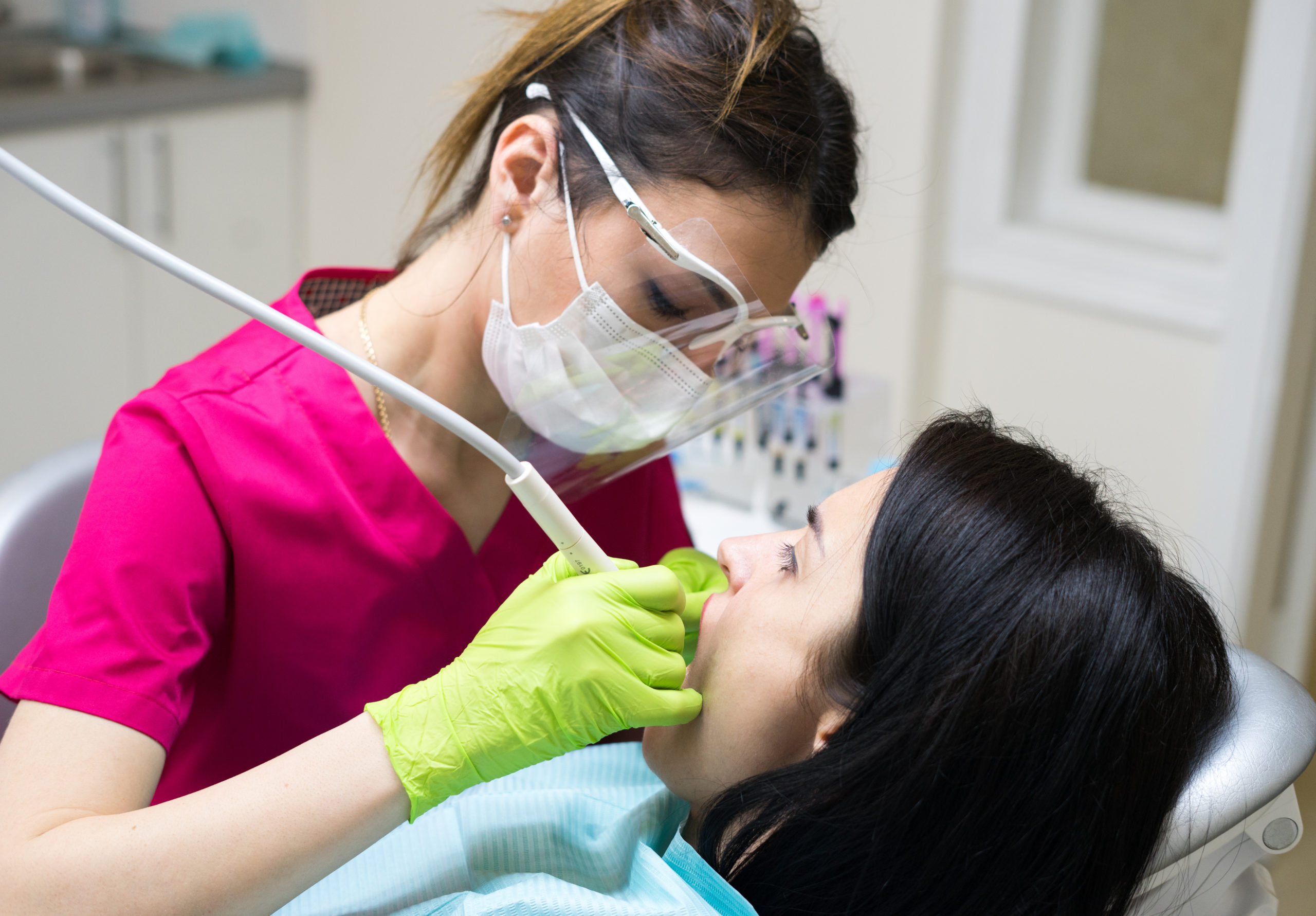 Hygienist cleaning teeth of a patient